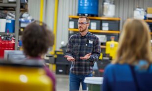 Trainer demonstrating hazardous materials handling in a professional workshop setting.